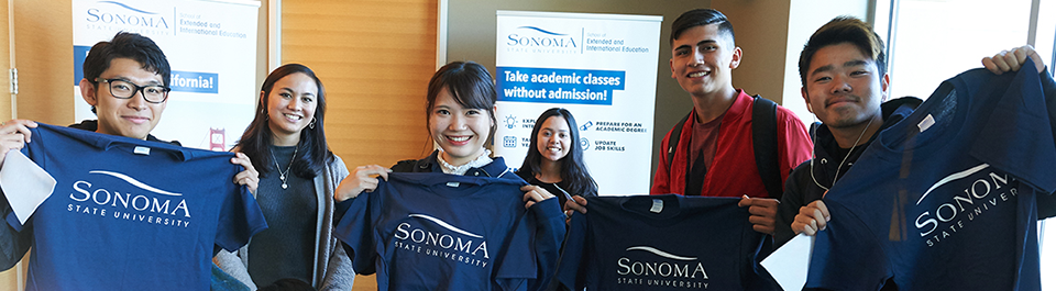 Students holding up their Sonoma State University t-shirts