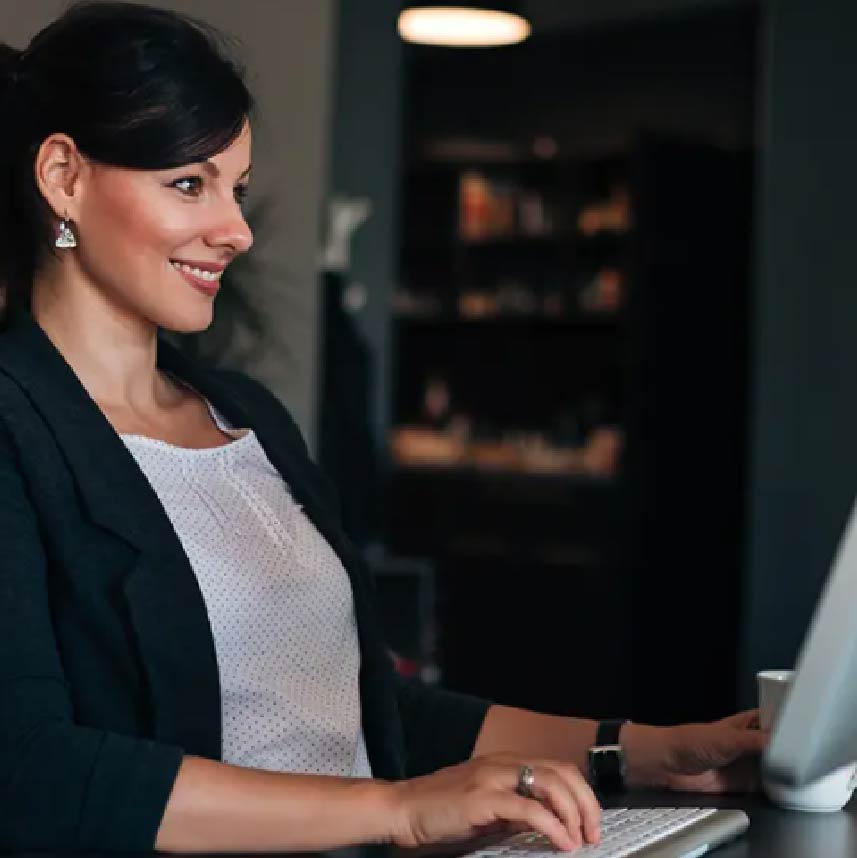 A smiling woman sitting at a computer