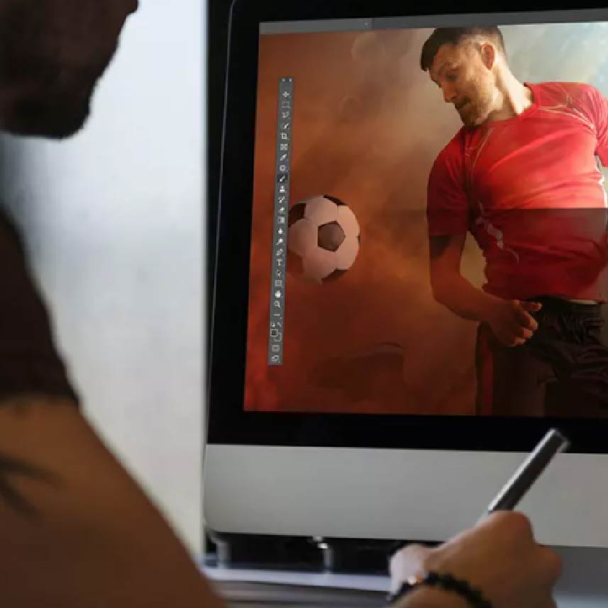 An individual looking at an image of a soccer player on the computer screen