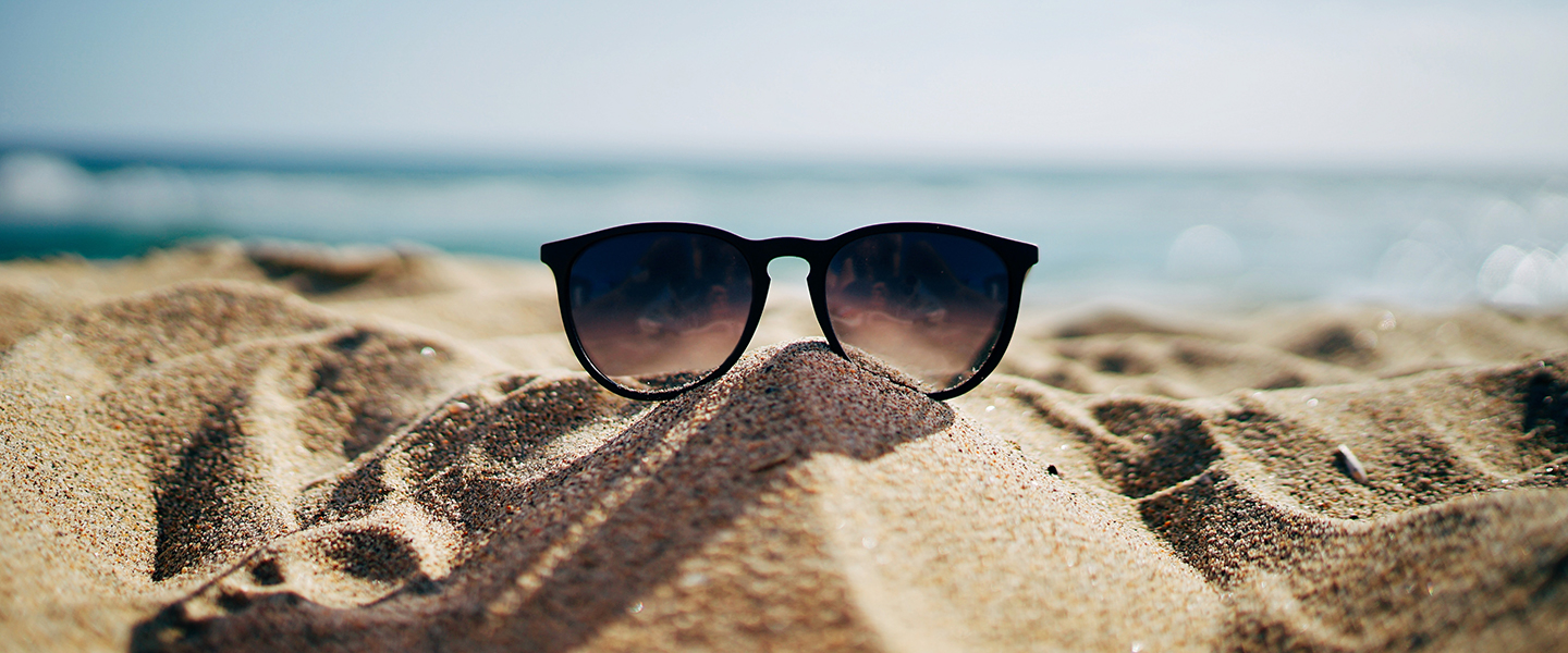 A pair of ladies' sunglasses on a beach